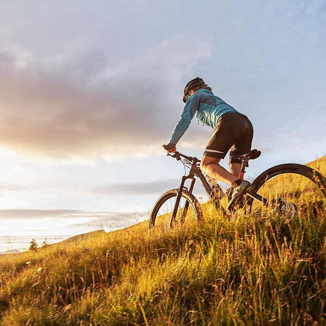 eBike rider going down a grassy hill