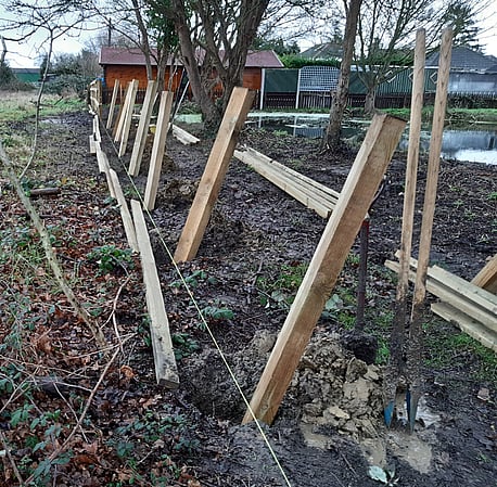 Timber posts and rail fencing being installed.