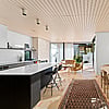 Shift House interior kitchen with dark cabinets and light bench top