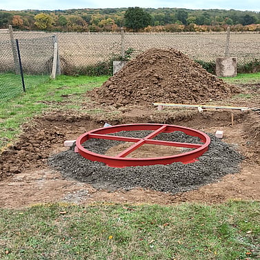 Image shows the new castor ring bedded down on to concrete footings in the excavated base. This has been leveled and is awaiting haunching  up.