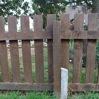 Image shows a concrete repair spur bolted to a timber post on a picket fence.