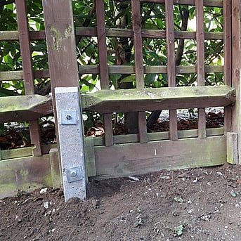 Image shows a repair spur bolted to a trellis fence using coach screws and plate washers for secure fixing. This method means the post can can stay in place while the repair is completed. Generally this method is the most cost effective.