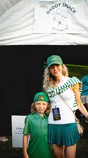 Woman and child in matching green golf outfits posing at a Daddy Shack Austin event