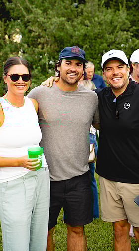 Group of guests smiling and posing at a Daddy Shack golf event