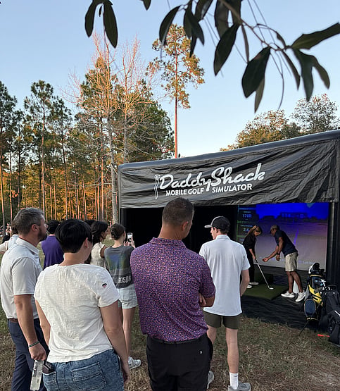 Crowd watches girl use Louisiana mobile golf simulator