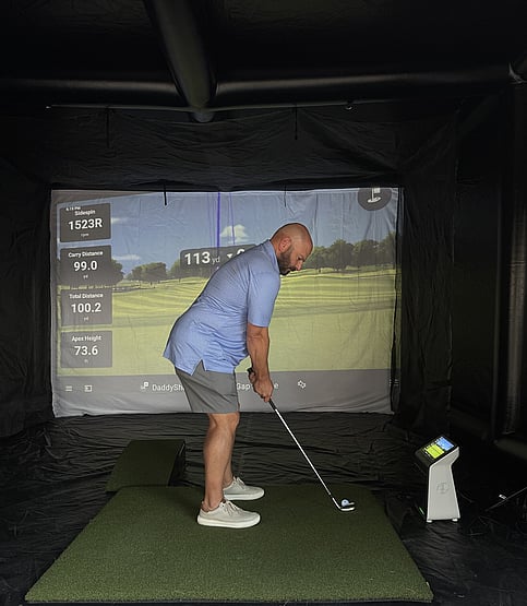 Man using the Lousisiana mobile golf simulator
