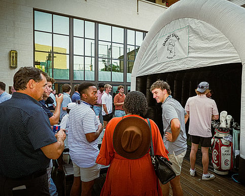 Fraternity socializing outside of the mobile golf simulator