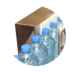 Bottles on conveyor belt running through air knives which are removing surface moisture (air blower technology)