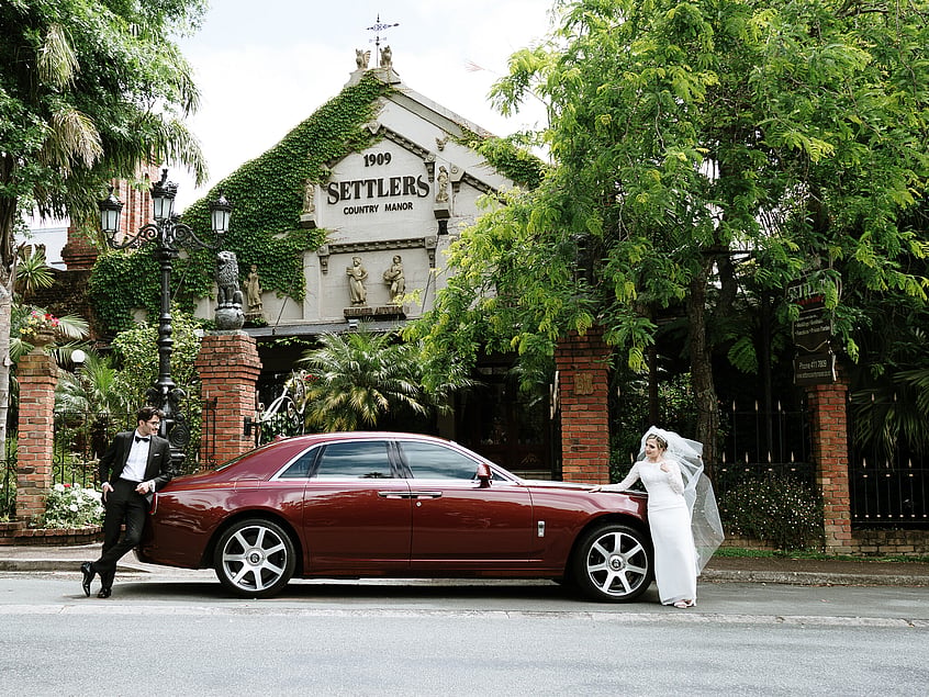 Bride and groom arriving by classic car at Settlers Country Manor wedding venue
