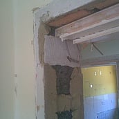 Asbestos insulation board used as packing behind a door frame