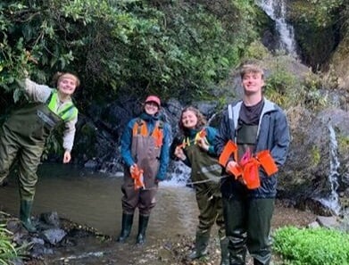 student tracking bats using a radio receiver & looking for sample bats with an attached radio transmitter.