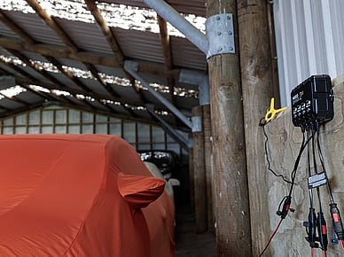 Vehicle connected to battery charger in PB Group indoor storage