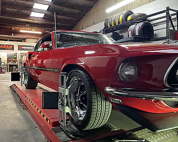Car wheel and tyre being fitted by a tyre technician