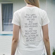 Person standing with their back to the camera wearing a shirt displaying a written message about purpose and values
