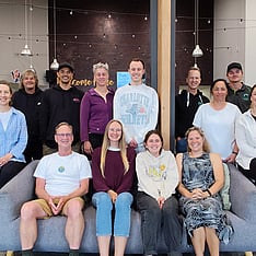 Group photo of a team seated together in a workplace environment