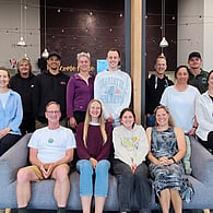 Group photo of a team seated together in a workplace environment