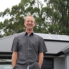 Phil Smiling in front of a house