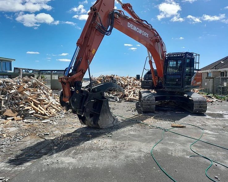 Demoworx excavator sorting timber from a house demolition