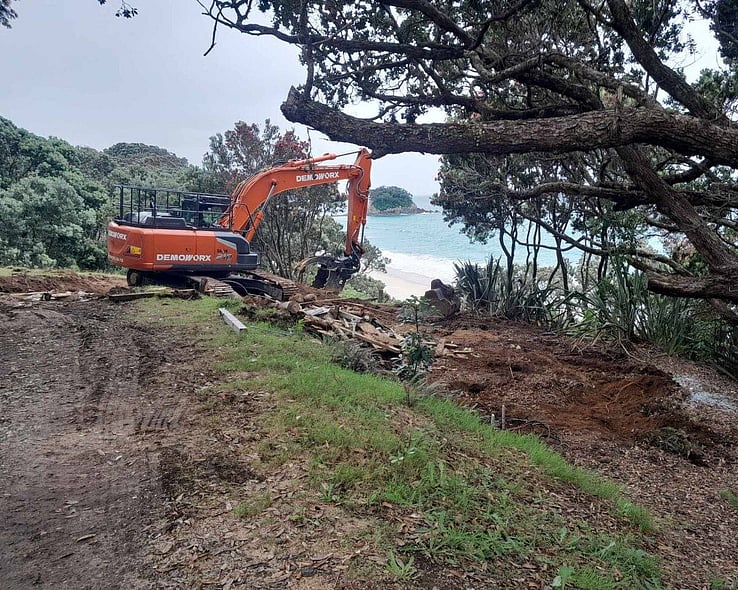 Excavator clearing a bank on a sloping site