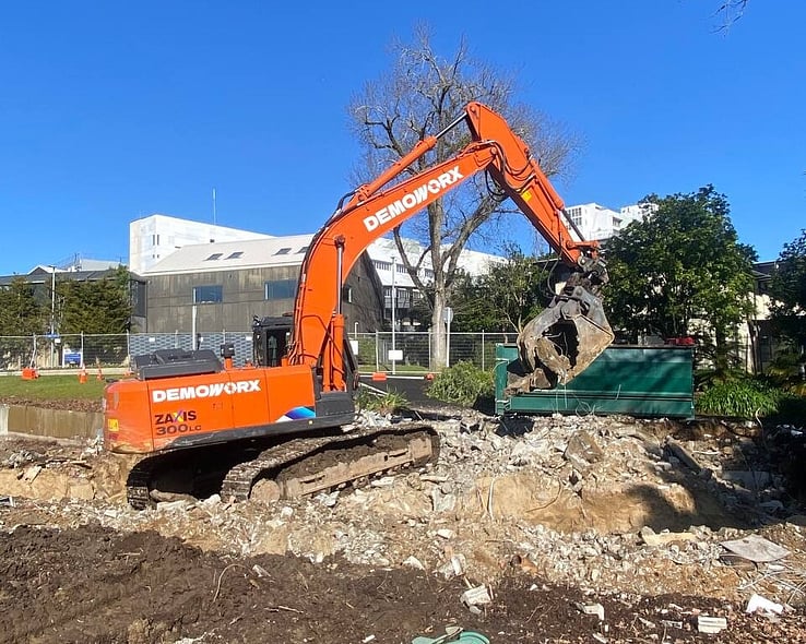 Excavator breaking up concrete on a site clearance