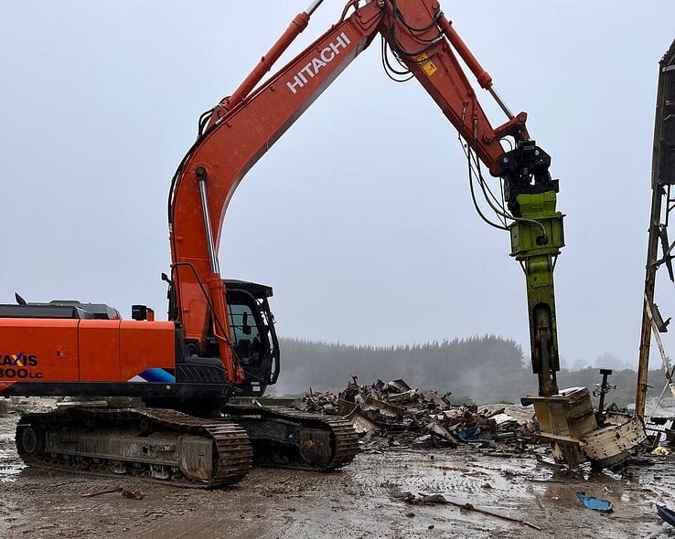 Excavator with a hydraulic breaker on a demolition site
