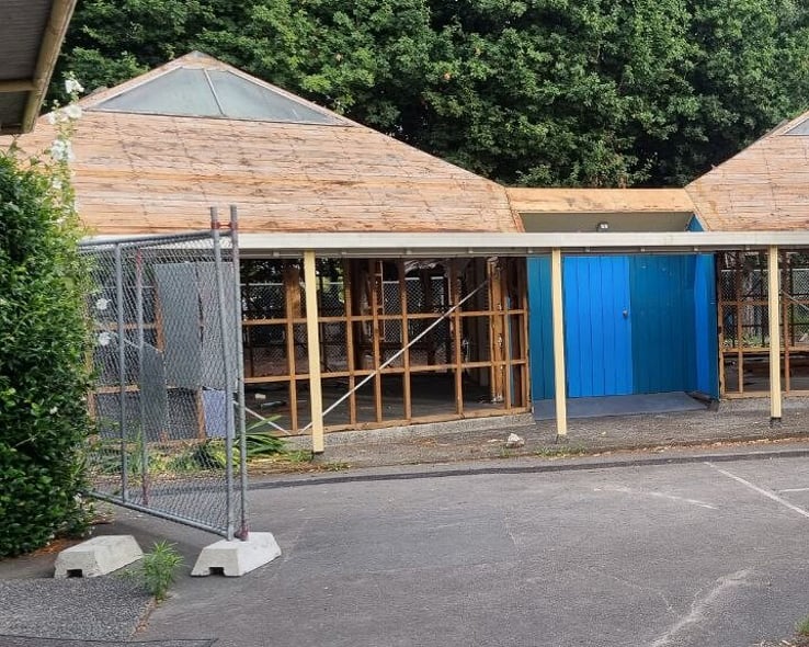 Timber-framed building partly stripped before demolition