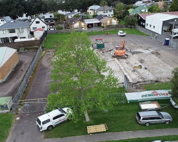 Aerial view of a site after demolition, with a Demoworx banner on the fence