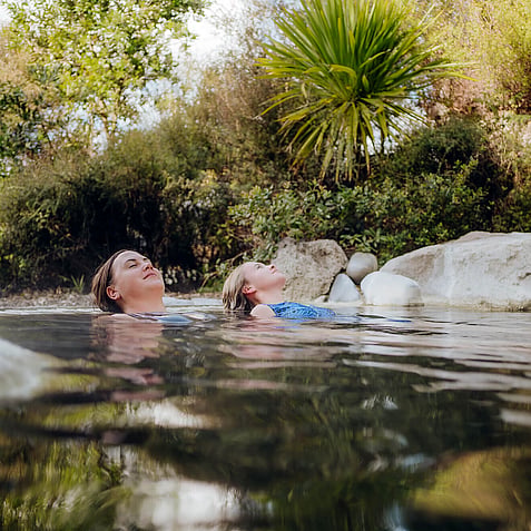 Guests floating and relaxing at Polynesian Spa Deluxe Lake Spa in Rotorua