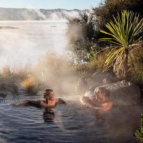 People relaxing in Polynesian Spa Deluxe Lake Spa pools overlooking Lake Rotorua