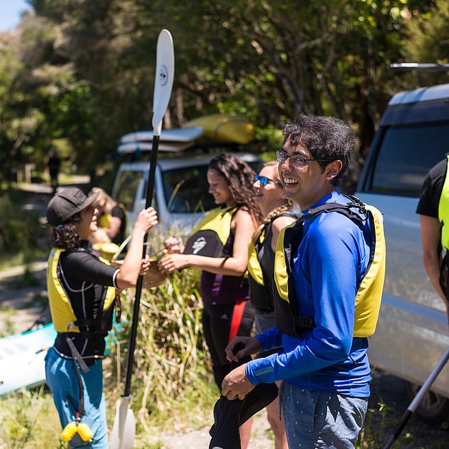 A customer smiles for the camera on the Steaming Cliffs Kayak Tour