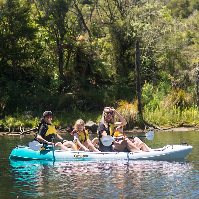 Women and Children kayak on Lake Rotomahana immersed in Waimangu Nature