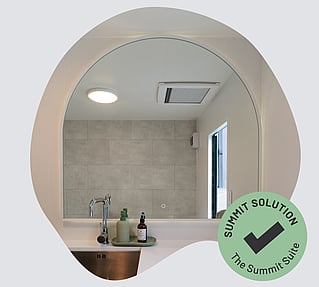 A large oval mirror in a portable bathroom.