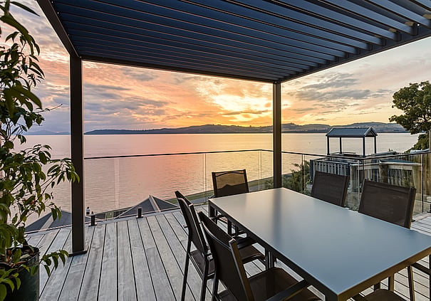 Outdoor dining area with lake views at a Roam Taupo upper terraceunit