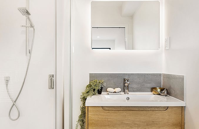 Image of a residential new build home bathroom. Single vanity with mirror and shower. Built by Auckland builders, Eden Construction. New Zealand.