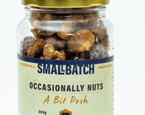 Occasionally Nuts &ndash; A Bit Posh gourmet nut mix in a clear pouch with golden accents, featuring a blend of premium roasted nuts and a hint of sweetness &mdash; a perfect artisan treat to complement floral and gift boxes from Flowers by Joanne.