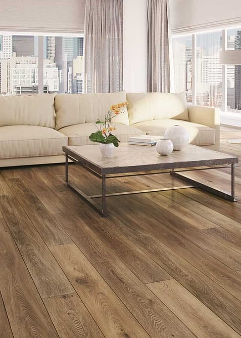 Medium wood look vinyl hybrid floor in a lounge with a low coffee table and white sofa. 