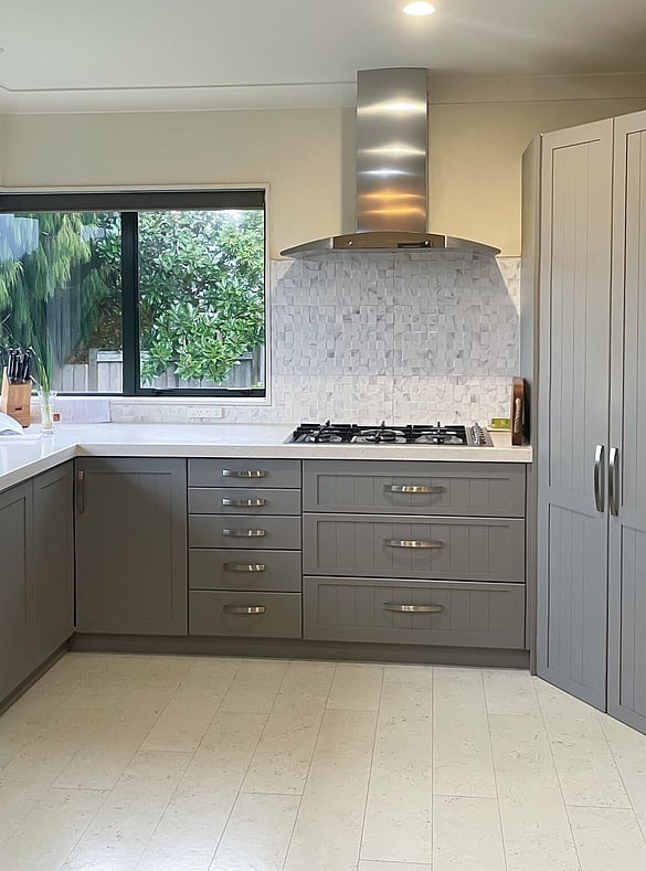 A modern dark grey kitchen with a white cork floor.