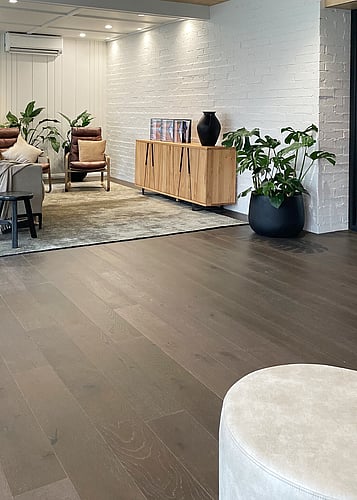 Dark wood flooring with white brick walls.