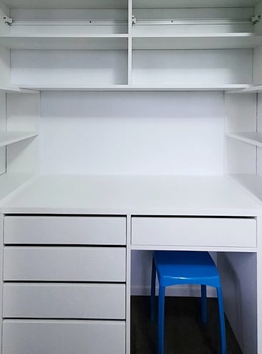 Built-in bedroom desk area with drawers, desk and blue stool