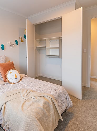 kids built-in wardrobe with doors open showing all hung reach-in wardrobe system.