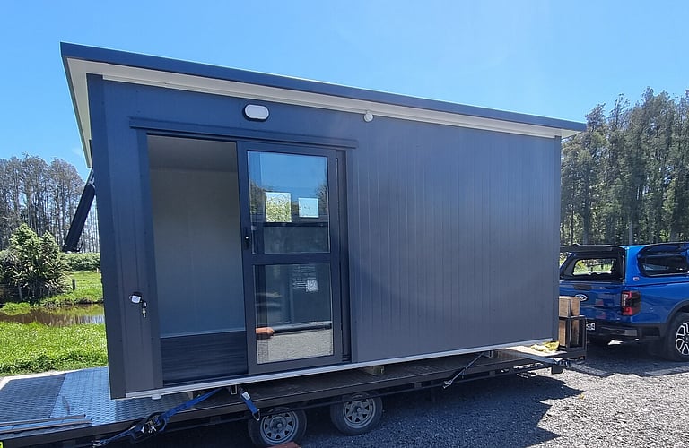4.6m x 2.7m grey cabin on a trailer ready for delivery.