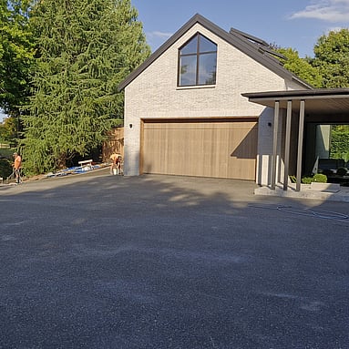 exposed aggregate concrete driveway in-front of house and garage 