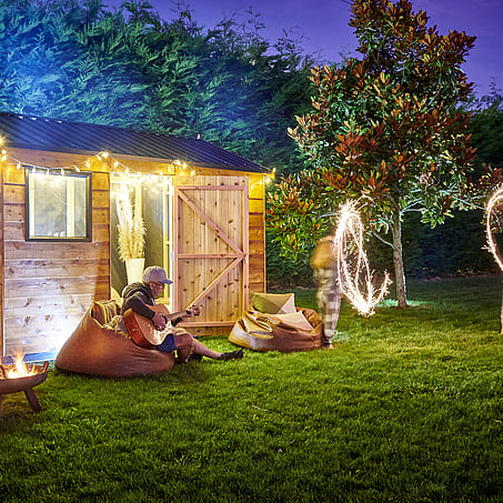 Craig Brown Photographer's image of a shed lit up at night with a family enjoying the outdoors