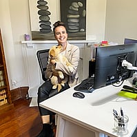 Image of Nicole Porima holding a dog in the office