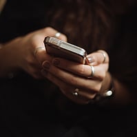 Image of someone looking at their phone representing Gallie Miles committing to good communication with clients