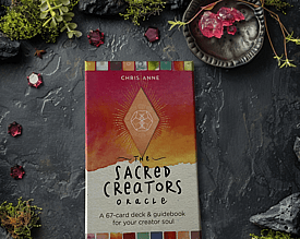 The Sacred Creators Oracle Deck on a moss and gem background with crystals