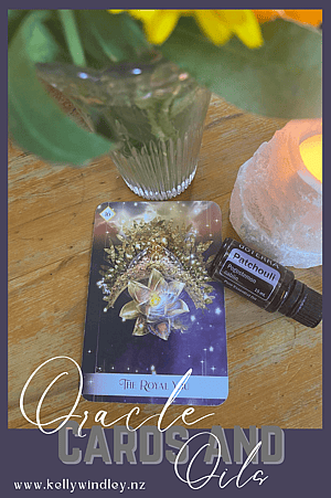 The Royal You Oracle Card, Patchouli Essential Oil, a candle and a vase of flowers