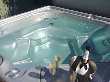 Luxurious spa pool with a champagne bottle in a cooler at Villa Rosa