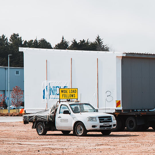 TDM Transport pilot vehicle escorting a wide load modular building unit, New Zealand