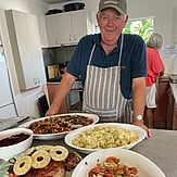 Comfort Kai image of man with plates of food on a table